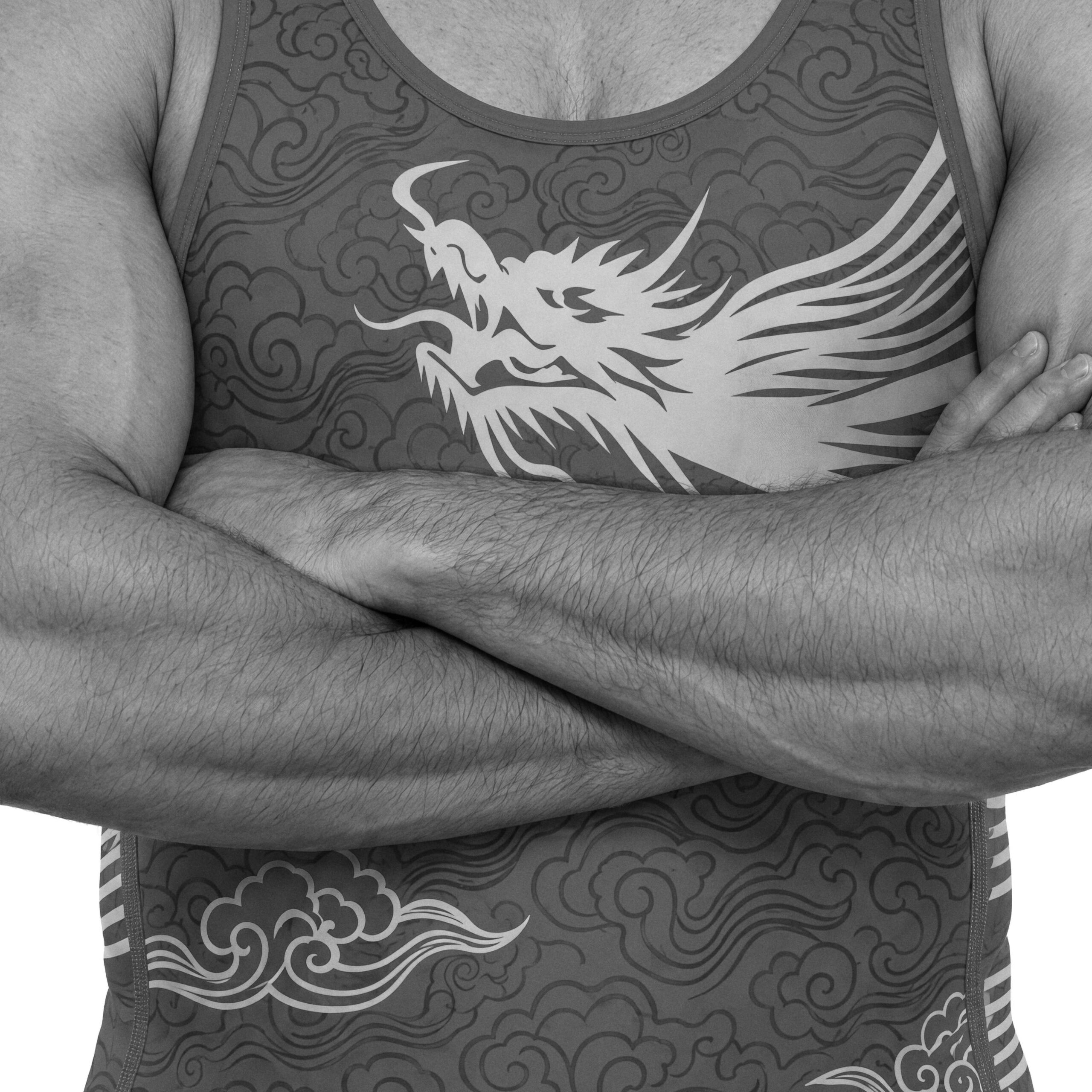 A wrestler with arms crossed, in a singlet printed with a dragon and clouds